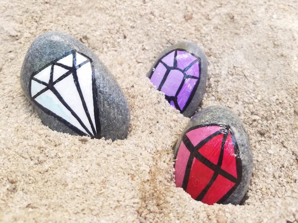 hand painted gem on smooth rocks.